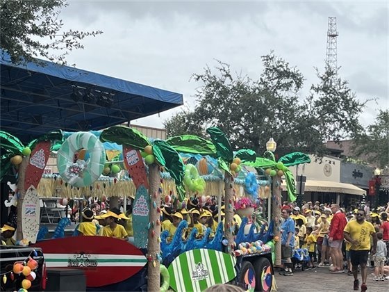Group of people standing in downtown behind a Hawaiian themed golf cart 