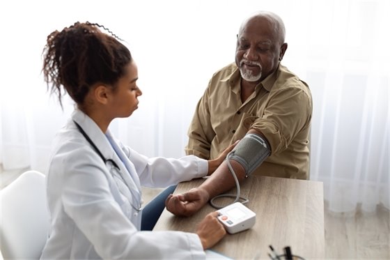 Doctor taking blood pressure of elderly man